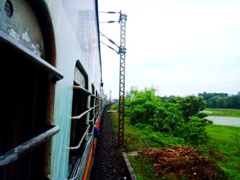 Train on railroad track amidst field against sky