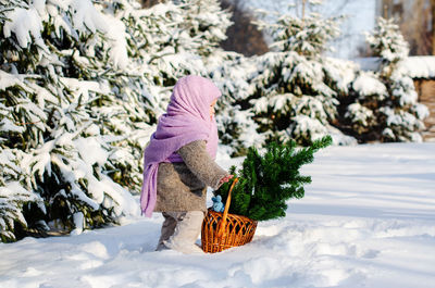 Woman standing on snow covered field