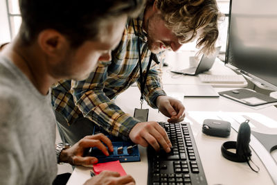 Male business coworkers working on computer at workplace