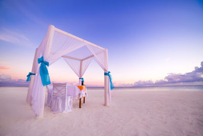 Romantic beach dinner setting with sunset sky. amazing couple honeymoon wedding destination scenic 