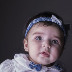 Portrait of cute baby against black background