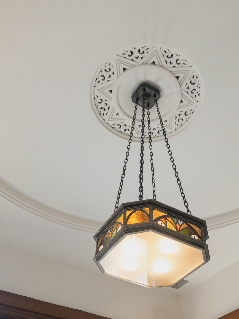 low angle view, lighting equipment, indoors, ceiling, illuminated, hanging, electricity, wall - building feature, no people, light, decoration, electric light, pendant light, home interior, chandelier, clock, glowing, technology, electric lamp, design, light fixture, electrical equipment, luxury, ornate, directly below