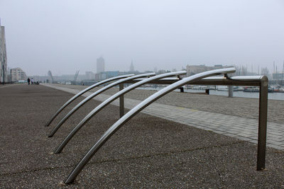 Empty bridge in city against sky