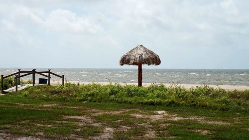 Hut on beach against sky