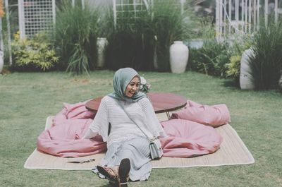 Portrait of woman sitting on field