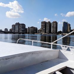 Modern buildings by sea against sky in city