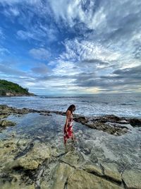 Full length of woman standing on beach against sky