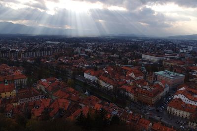 Townscape against sunbeams streaming from sky