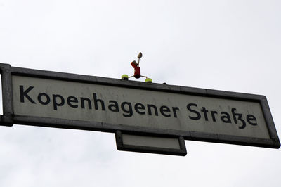 Low angle view of information sign against sky