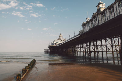 Jetty extending to sea against the sky