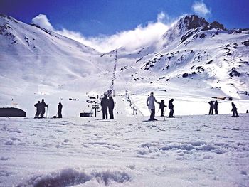 People skiing on snow covered landscape