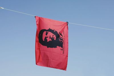 Low angle view of flag against clear blue sky