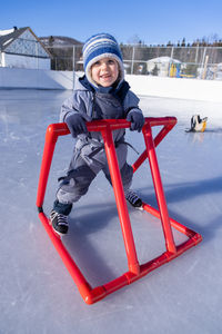Portrait of boy sitting on slide at playground