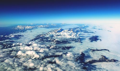 Scenic view of snow covered mountains against blue sky