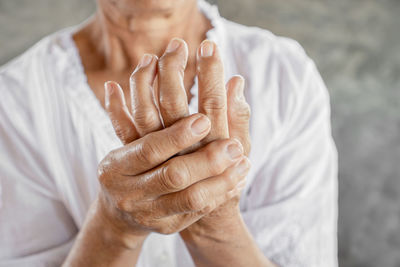 Close-up of senior woman with wrinkled fractured hands