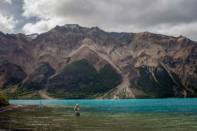 Scenic view of sea by mountains against sky