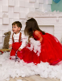 Side view of mother and daughter on snow