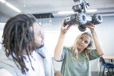 Engineer looking below robotic car with technician at workshop