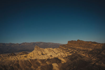 Scenic view of desert against clear blue sky