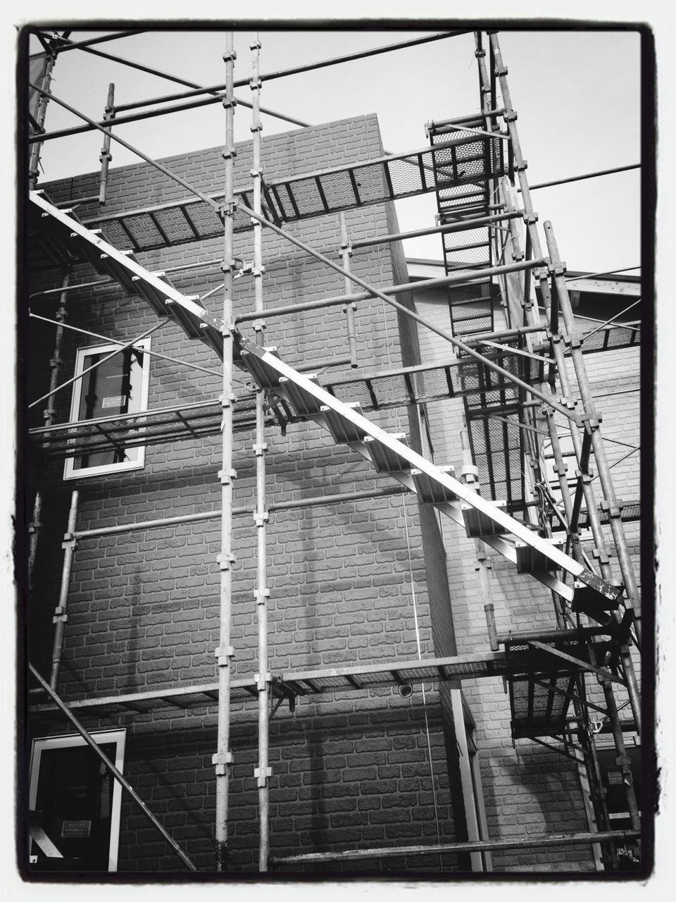 architecture, built structure, building exterior, low angle view, transfer print, construction site, auto post production filter, building, city, metal, construction, day, development, sky, power line, outdoors, window, scaffolding, no people, incomplete