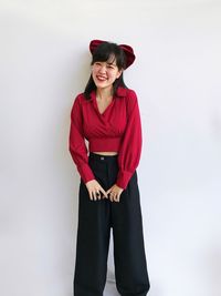 Portrait of a smiling young woman against white background