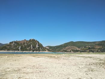 Scenic view of beach against clear blue sky