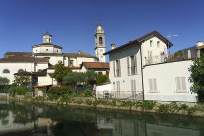 Reflection of buildings in water against clear sky