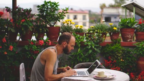 Midsection of man using mobile phone while sitting on table