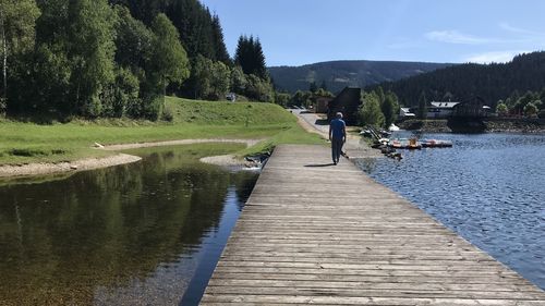Rear view of man by lake against sky / biking in austria 