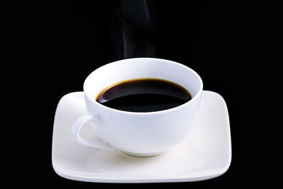 Close-up of coffee cup against black background