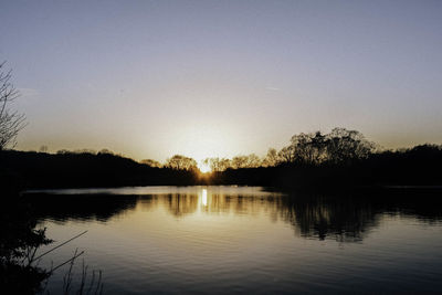 Scenic view of lake against clear sky during sunset