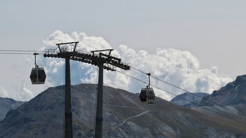 Overhead cable car over snowcapped mountains against sky