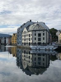 Buildings by lake against sky in city