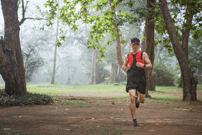 Full length of man running on footpath in forest