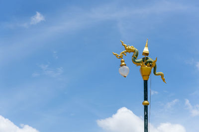 Low angle view of street light against blue sky