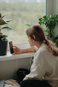 A young pretty woman in headphones communicates via video chat with mobile phone. high quality photo