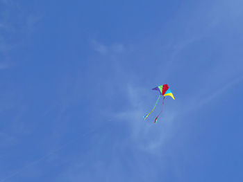 Low angle view of kite flying against clear blue sky