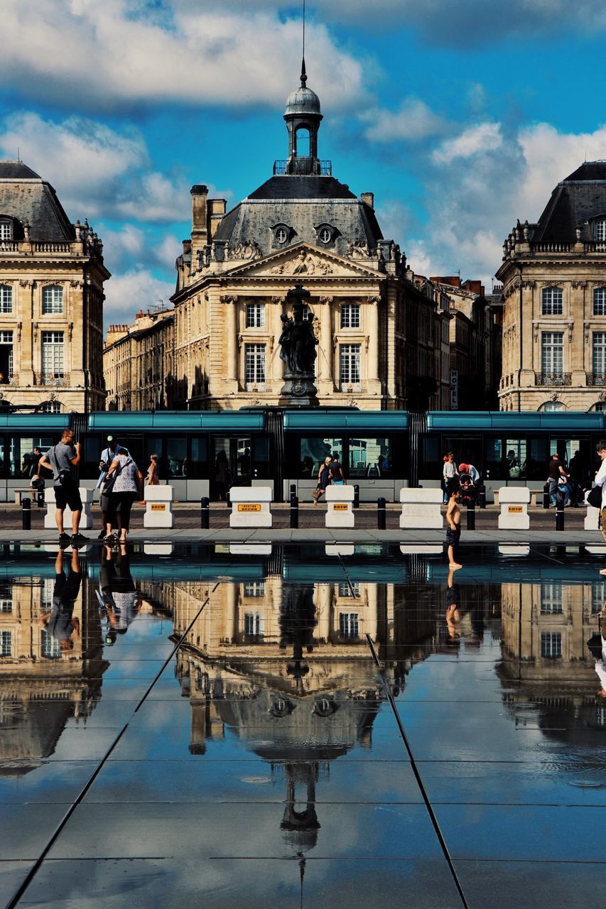 architecture, building exterior, sky, built structure, cloud - sky, reflection, nautical vessel, day, mode of transport, waterfront, transportation, outdoors, water, statue, dome, men, moored, sculpture, large group of people, baroque style, real people