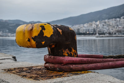 Close-up of rusty metal on beach against sky