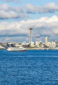 Architecture of the seattle skyline with elliott bay in front and clouds above. 