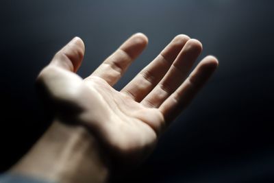Close-up of human hand against black background