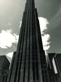 Low angle view of skyscrapers against cloudy sky