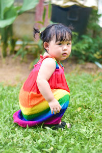 Portrait of cute girl sitting on field