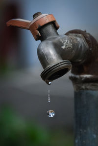 Close-up of water drop from faucet