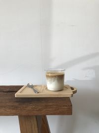 Close-up of beer glass on table against wall at home