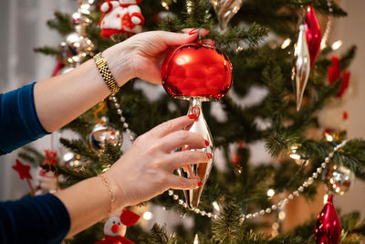 Hanging baubles on the christmas tree, women's tiles, painted nails