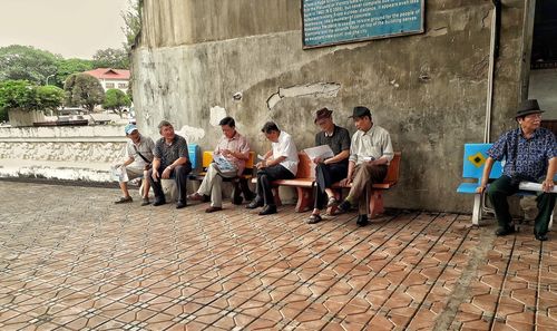 People sitting on bench in street