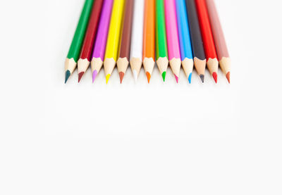 High angle view of multi colored pencils against white background