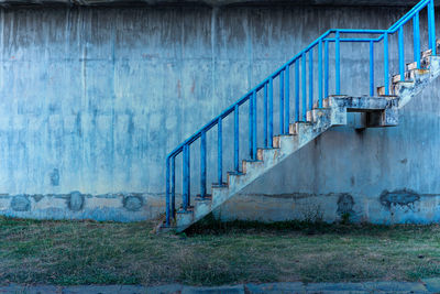 Rusty metal railing against wall