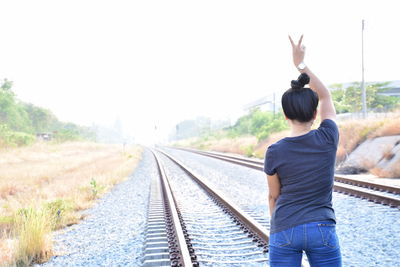 Rear view of man standing on railroad track